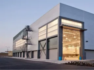 Modern industrial warehouse at dusk representing the need for expert fort lauderdale commercial plumbing and comprehensive Sewer Line Inspections for manufacturing plants.